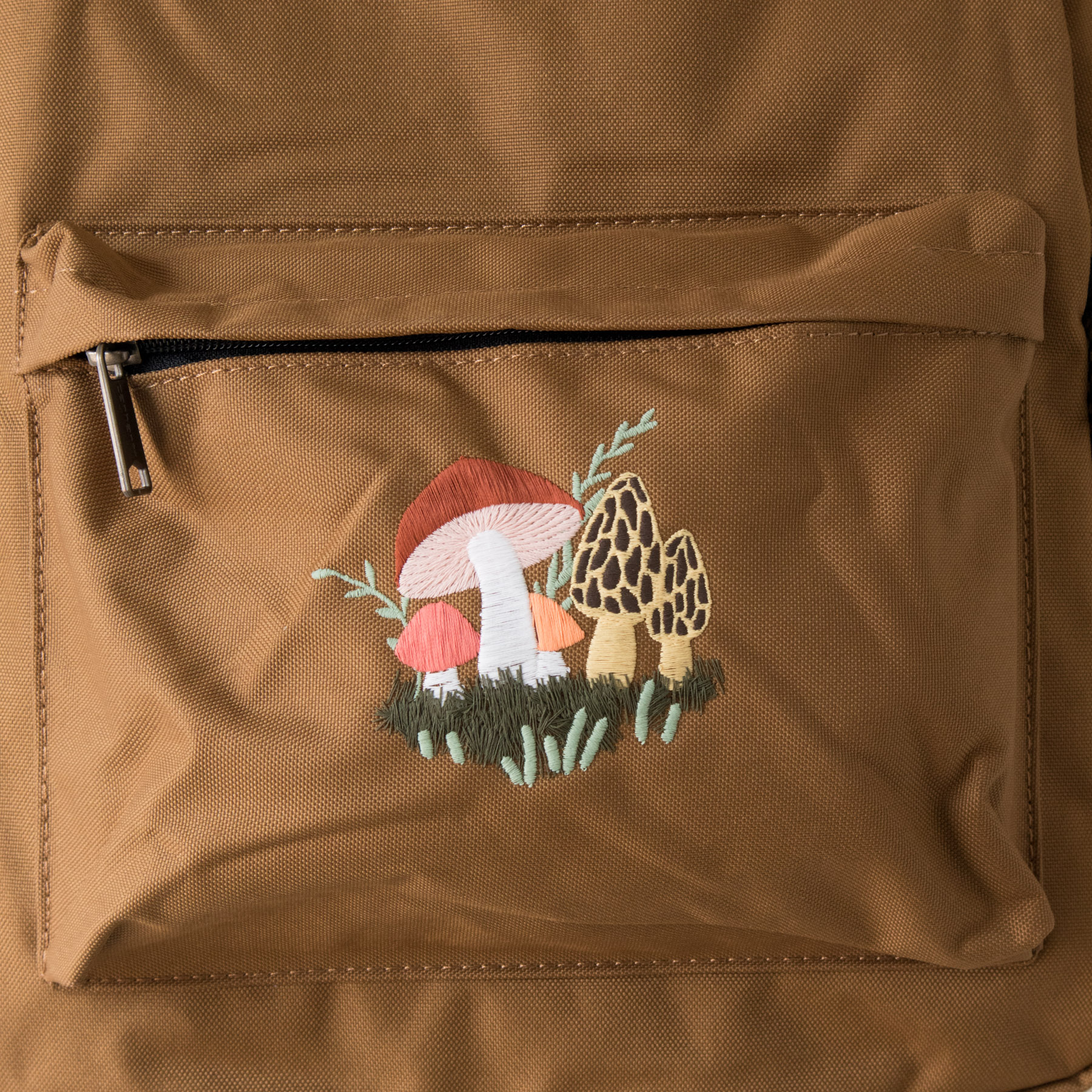 Product image - brown Carhartt backpack with embroidered mushroom design detail