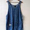 Vintage denim coveralls with three buttons on each side and two front pockets. the front right pocket features custom embroidery of a fawn laying peacefully amongst flowers.