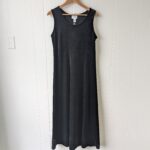 Front of the dress hanging on a hanger. Plain black velvet long dress.