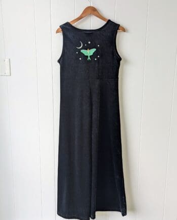 the back of a long black velvet dress embroidered on the top middle back with a luna moth surrounded by a crescent moon and several small stars.